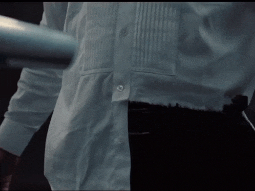 a man in a white shirt is holding a metal bar