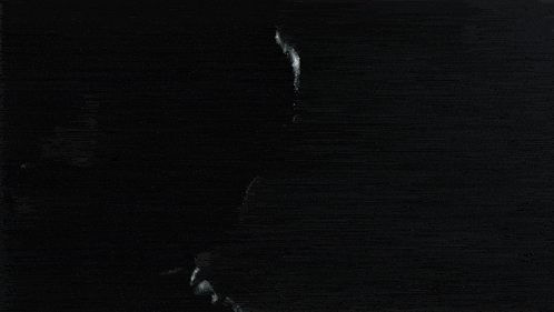 a silhouette of a man in a batman costume standing in the dark