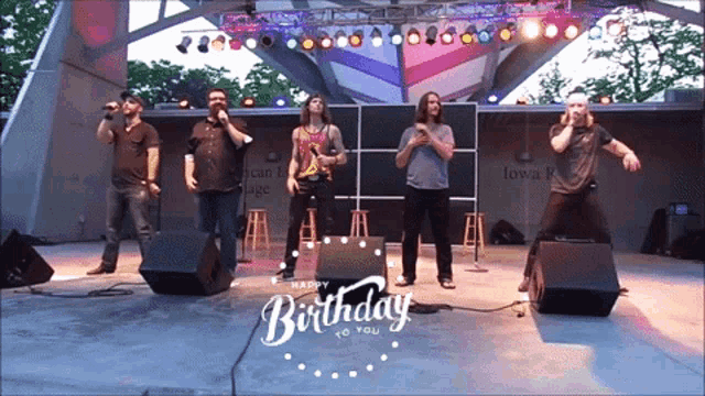 a group of men singing and dancing on a stage with the words happy birthday to you