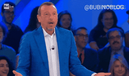 a man in a blue suit stands in front of a crowd of people and says bubinoblog