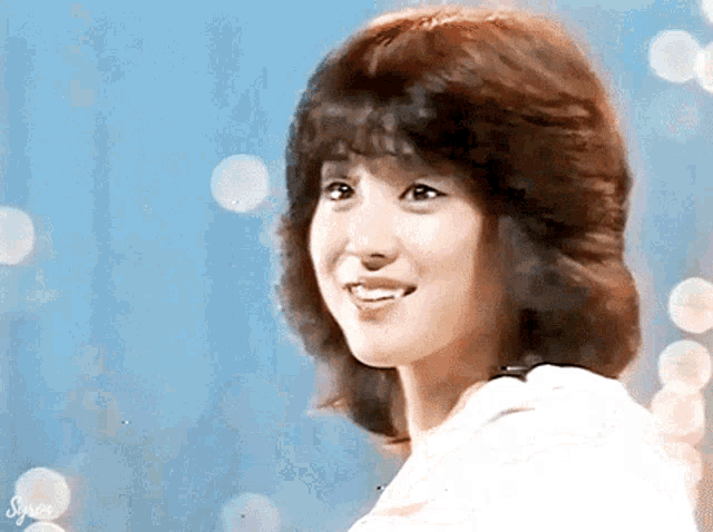 a close up of a woman 's face with a blue background and the word singer visible