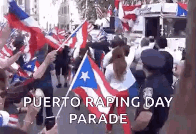 a group of people are walking down a street holding flags and a police officer is standing behind them .