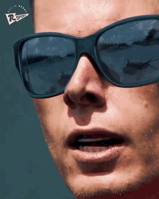 a close up of a person wearing sunglasses with a rsport logo on the bottom