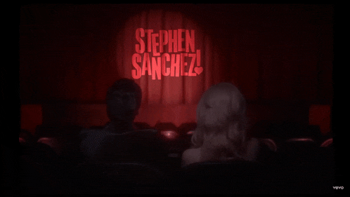 a man and a woman sit in front of a stage that says stephen sanchez on it