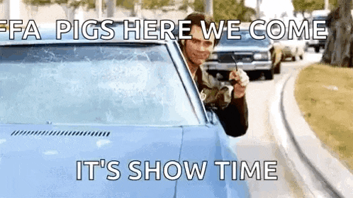 a man is sticking his head out of a car window while holding a remote control .