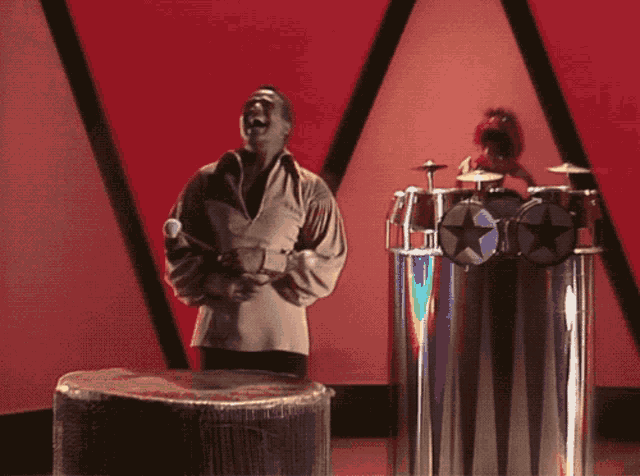a man is kneeling in front of a drum set with a star on it