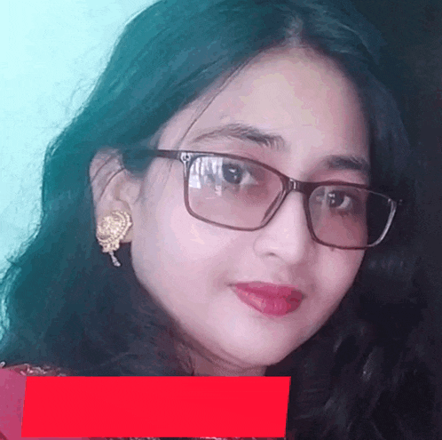 a woman wearing glasses and gold earrings is smiling
