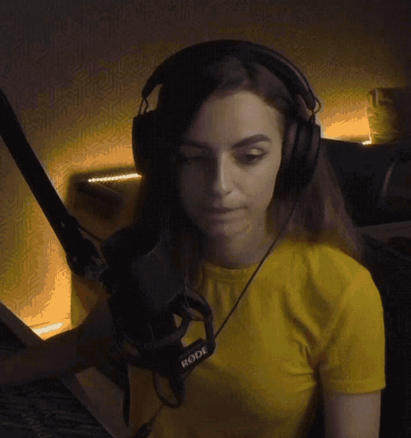 a woman wearing headphones and a yellow t-shirt has rode written on her microphone