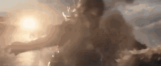 a person is flying through the air with the sun shining through the clouds behind them .