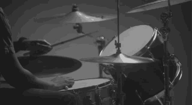 a man is playing a drum set in a black and white photo