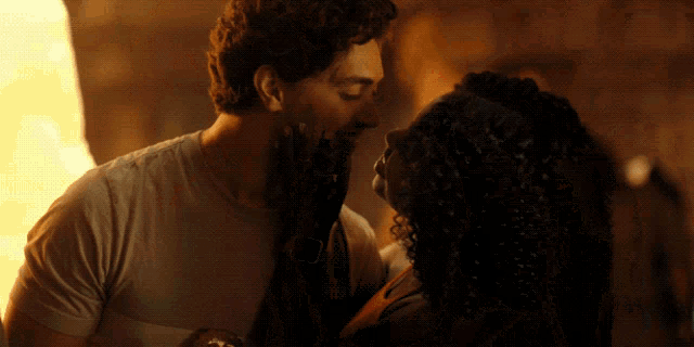 a man and a woman are kissing and the woman is holding the man 's face