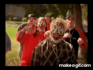 a group of men wearing clown masks are standing in a field .