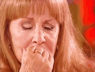 a woman with a ring on her finger is covering her mouth