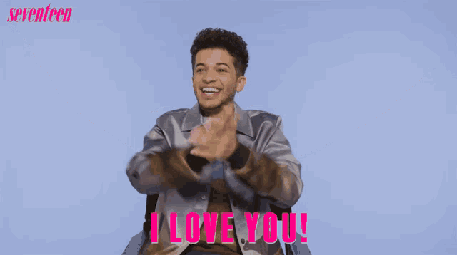 a man with his arms outstretched says " i love you " in pink