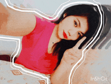 a woman in a pink shirt giving the peace sign
