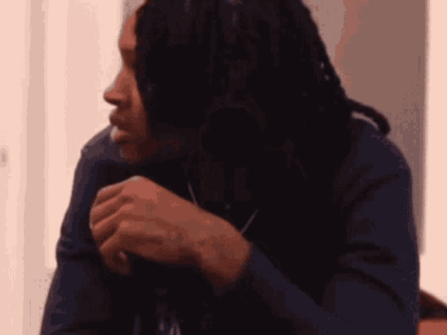 a man with dreadlocks is wearing a blue shirt that says ralph lauren