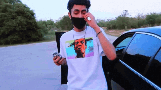 a man wearing a black mask and a white shirt with a picture of a man on it