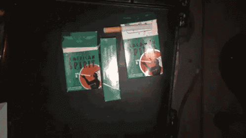 two boxes of american spirit cigarettes are on a black surface