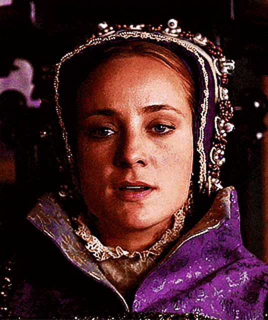 a woman wearing a purple jacket and a purple headpiece