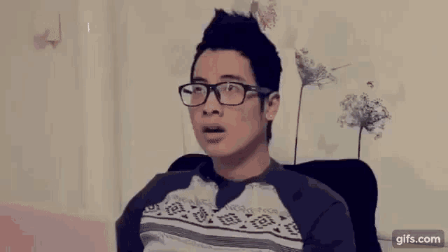 a man wearing glasses is sitting in a chair with the words deo and tin 3 above him