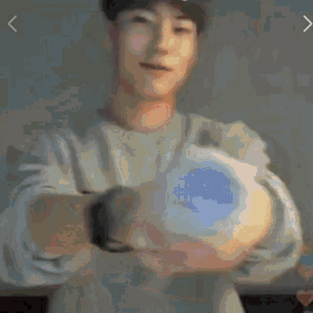 a blurry picture of a man holding a blue ball in his hands