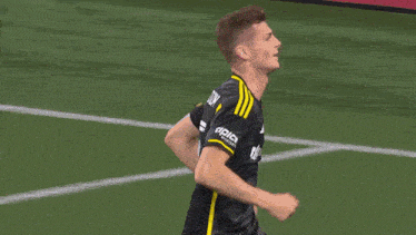 a soccer player kicks the ball in front of a sign that says relas