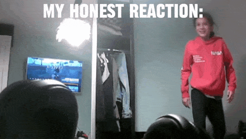 a girl wearing a nasa sweatshirt is standing in front of a mirror