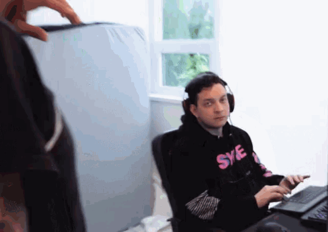 a man wearing headphones and a hoodie that says sye on it