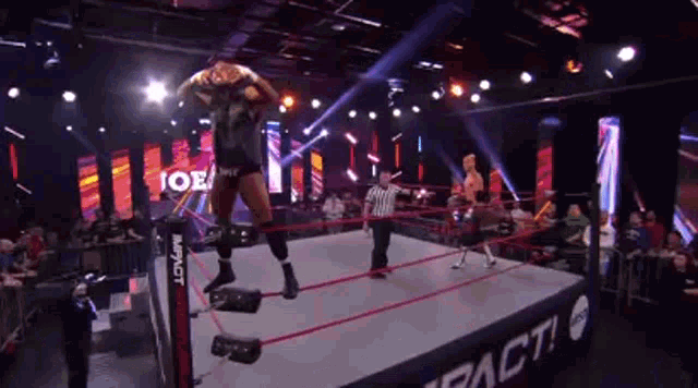 a wrestling match is being held in a ring with a referee .