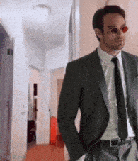 a man in a suit and tie is wearing sunglasses .