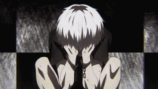 a man in handcuffs covering his face with his hands in a dark room