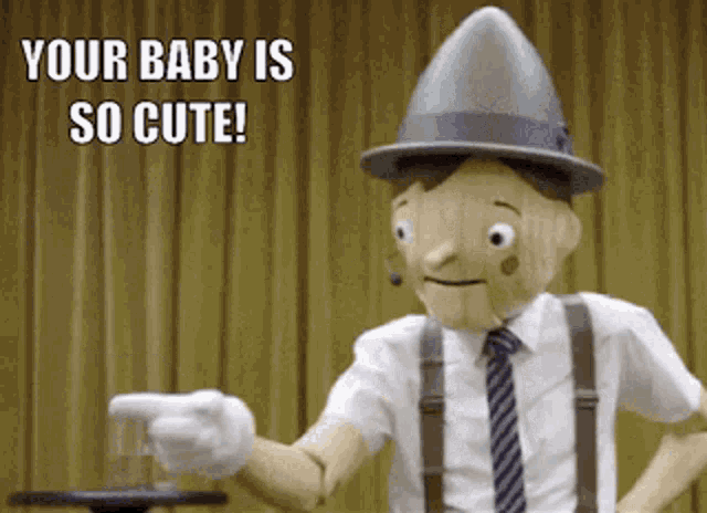 a puppet with a hat and suspenders is pointing at something with the caption " your baby is so cute "
