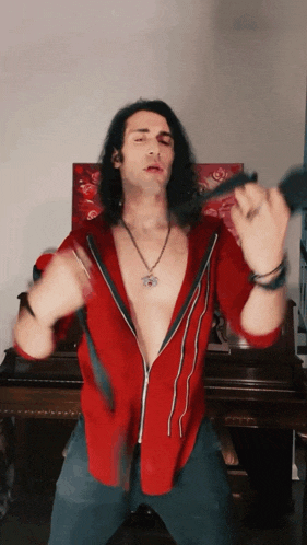 a man with long hair and a red shirt is holding a microphone