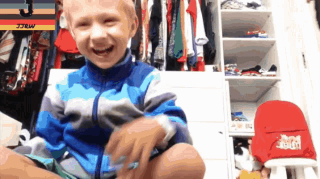 a boy is sitting in front of a closet with a sign that says mr. jr.c.c.