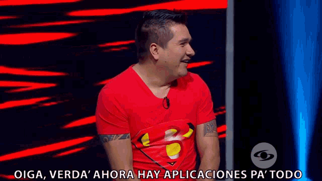 a man wearing a red shirt with a superman logo on it