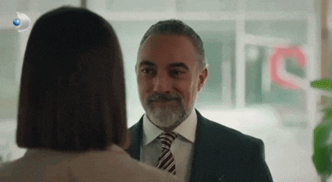 a man in a suit and tie is looking at a woman in a suit and tie .