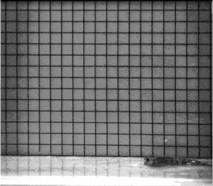 a black and white photo of a checkered wall and a table .