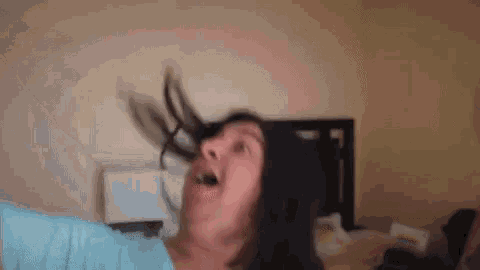 a woman is making a funny face with her hair in the air