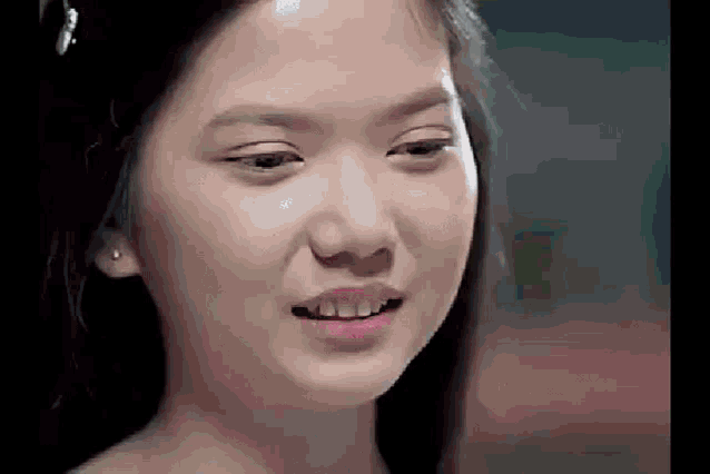 a close up of a young girl 's face with a tear coming out of her eyes .