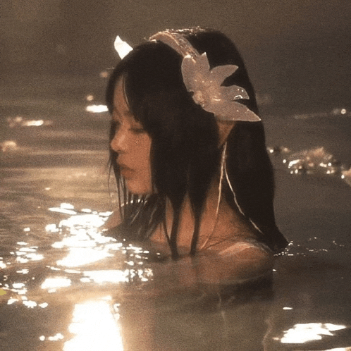 a woman in a bathtub with a flower on her head