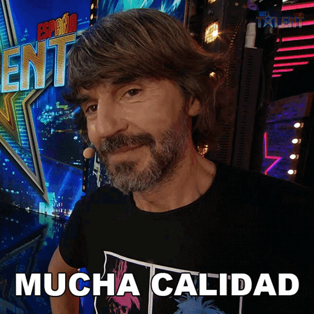 a man with a beard is standing in front of a sign that says mucha calidad