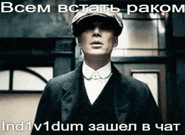 a man in a suit and hat is standing in front of a sign that says " всем встать раком "