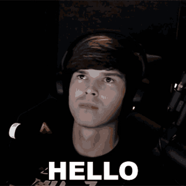 a man wearing headphones and a black shirt says hello