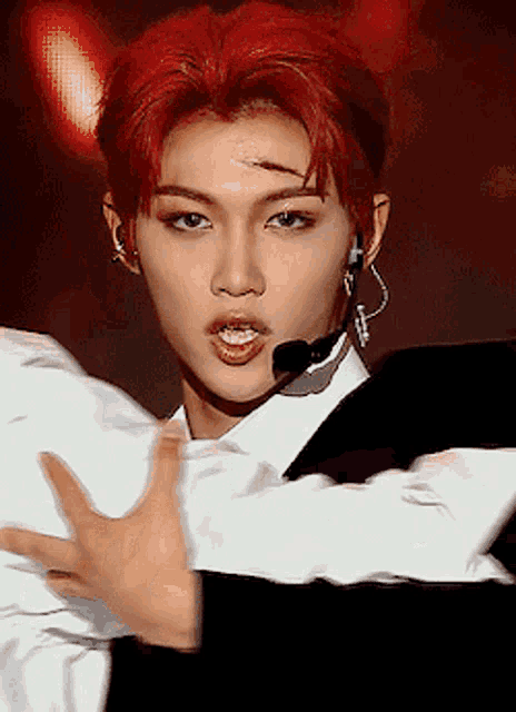 a man with red hair is wearing a microphone and a white shirt