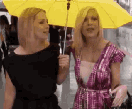 two women are holding an umbrella in the rain