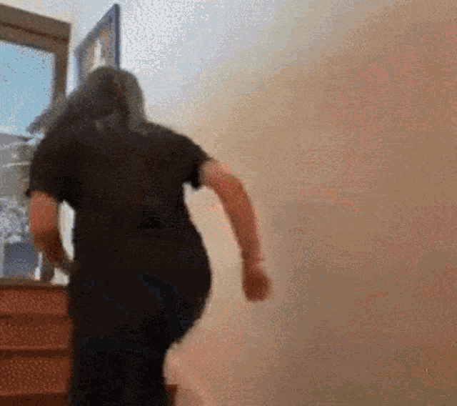 a woman in a black shirt is walking up a set of stairs