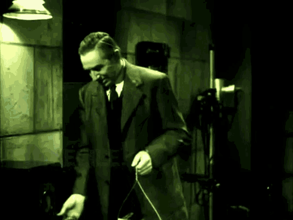 a man in a suit and tie is standing in a dark room with the words bombastic ignoramus written in green