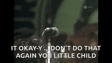a man is singing into a microphone and says `` it okay-y ... don 't do that again you little child ''