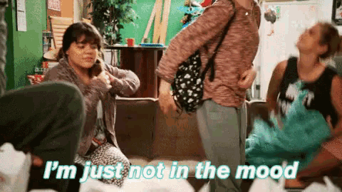 a group of people are sitting on a couch and one of them says i 'm just not in the mood .