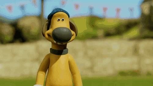 a cartoon dog wearing a blue hat and a collar is standing in the grass .